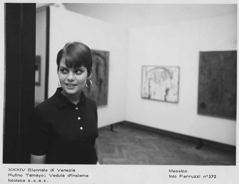 Black and white photo of Carla standing in a gallery during the Venice Biennale, 1968.